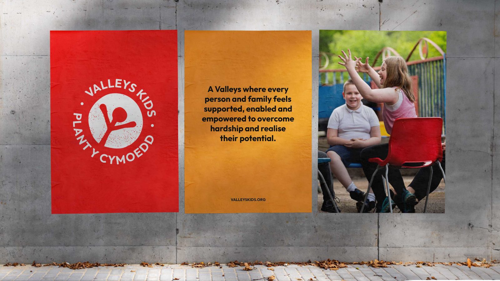 Two promotional banners displayed on a gray concrete wall. The left banner, created by a brand design agency, features a red logo with the text 