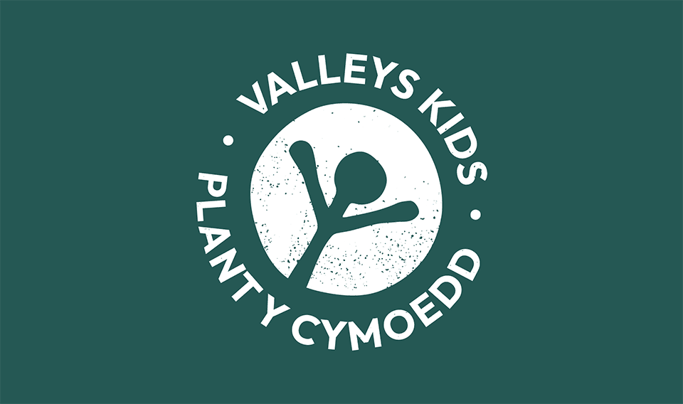 Logo of valley's kids designed by a Design Agency UK, featuring a white circular emblem with two abstract figures forming a 'k', surrounded by stars, on a dark green background, including the text 