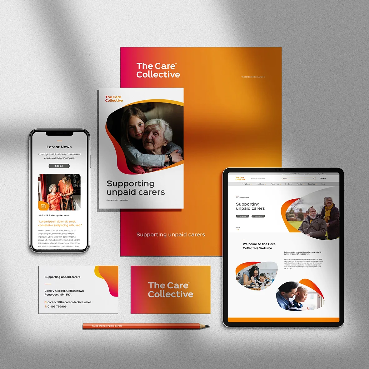 A collection of promotional materials for the care collective, featuring a smartphone, a tablet, brochures, and sheets updated with brand design elements and supporting information for unpaid carers.