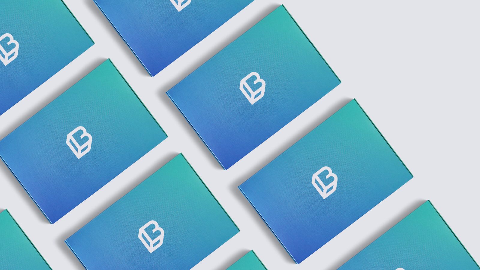 Multiple business cards in teal and blue featuring a white letter 