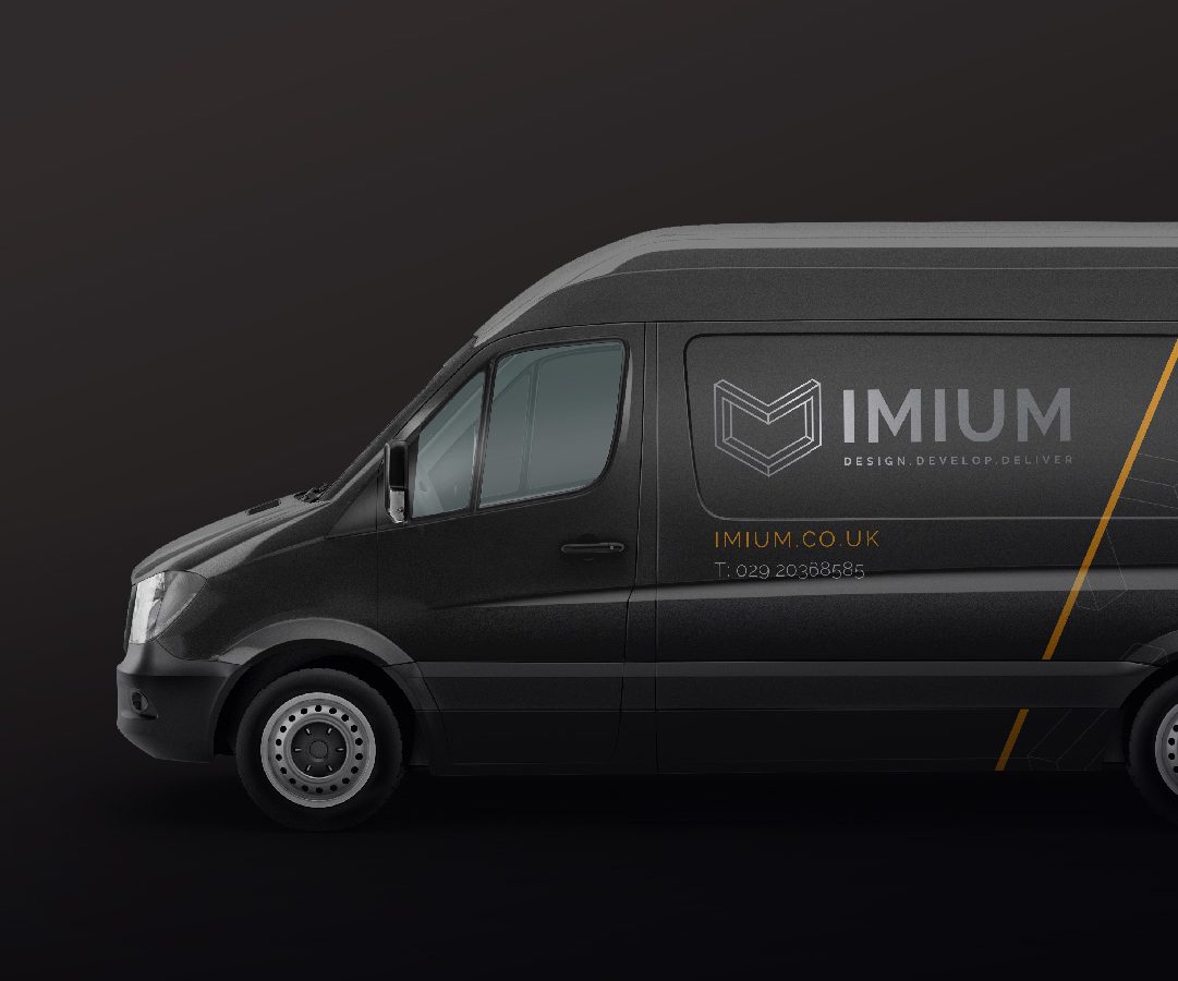A dark gray delivery van with the logo 
