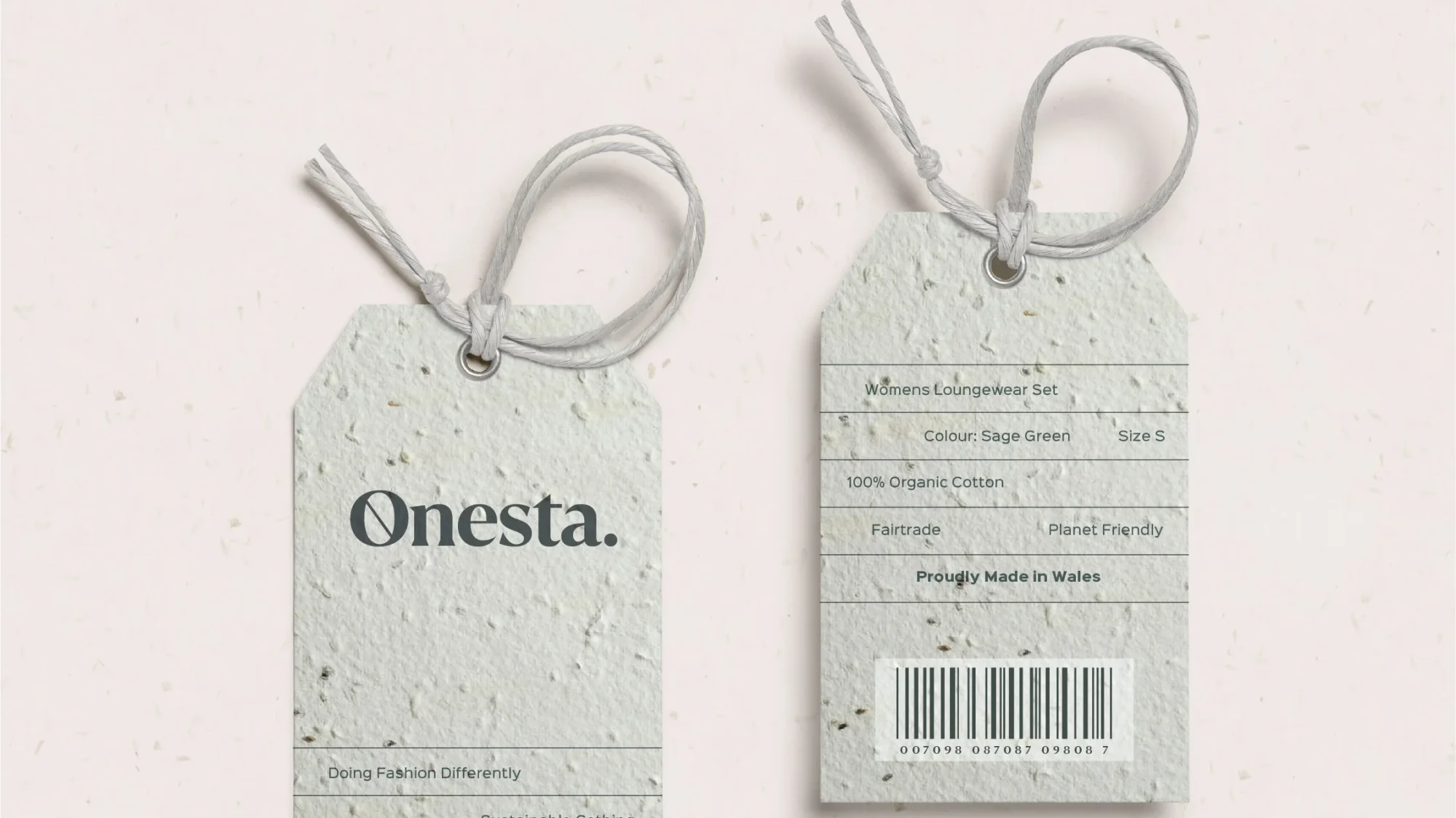 Two clothing tags designed by a design agency in Wales for the Onesta brand on a speckled paper background. One shows the front with the brand logo, and the other displays sizing, material information