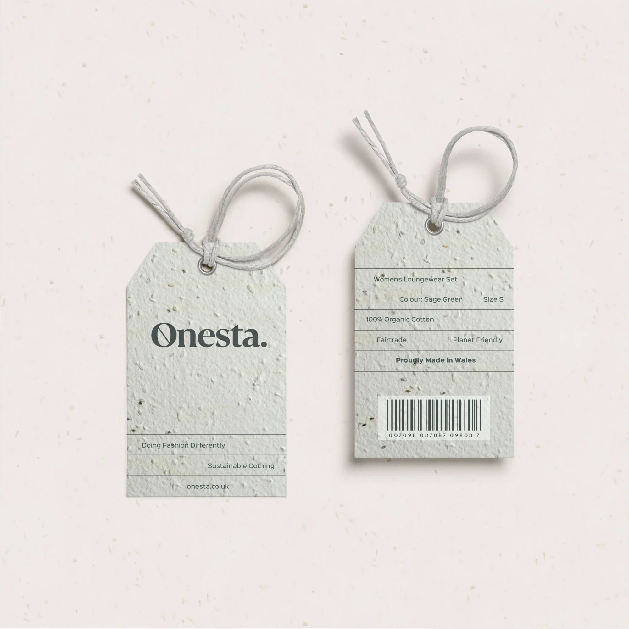 Two clothing tags designed by a design agency in Wales for the Onesta brand on a speckled paper background. One shows the front with the brand logo, and the other displays sizing, material information