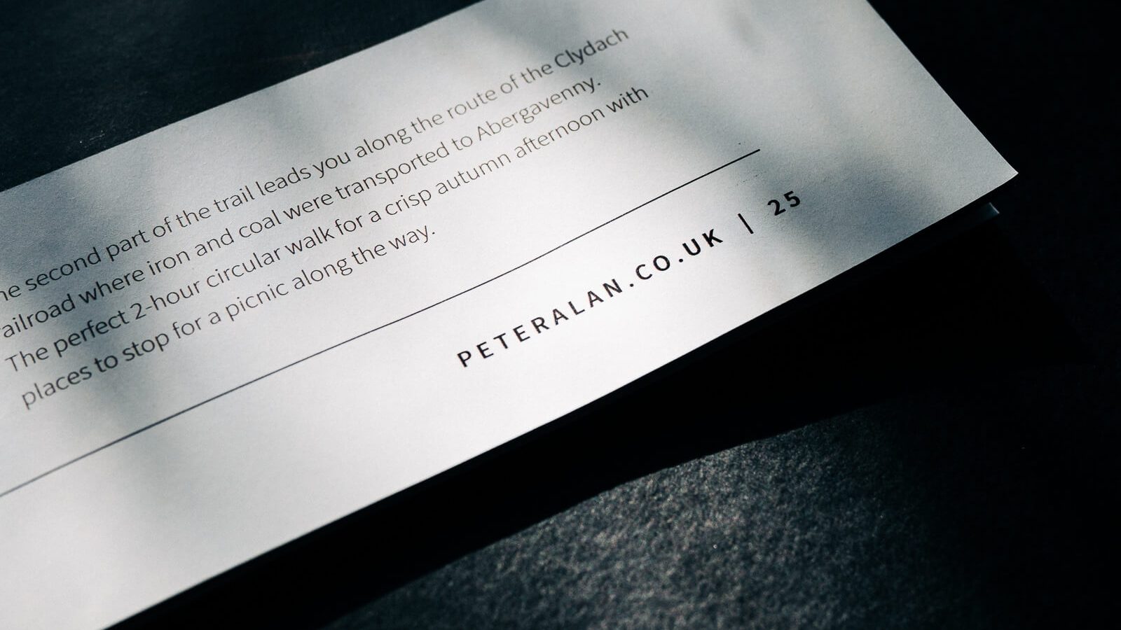 A strip of paper with text lies on a textured dark surface, illuminated by a streak of light, highlighting specific content and a Web Agency Bristol address, 