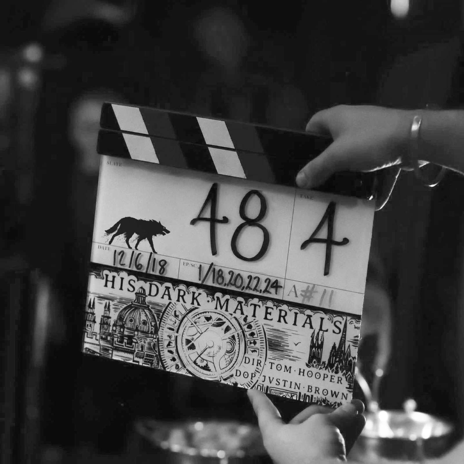 A monochrome image of a person holding a clapperboard for the TV series 