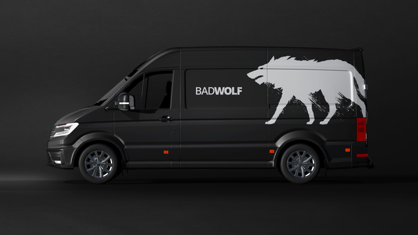 A black van parked against a dark background, featuring a large white wolf graphic and the text 
