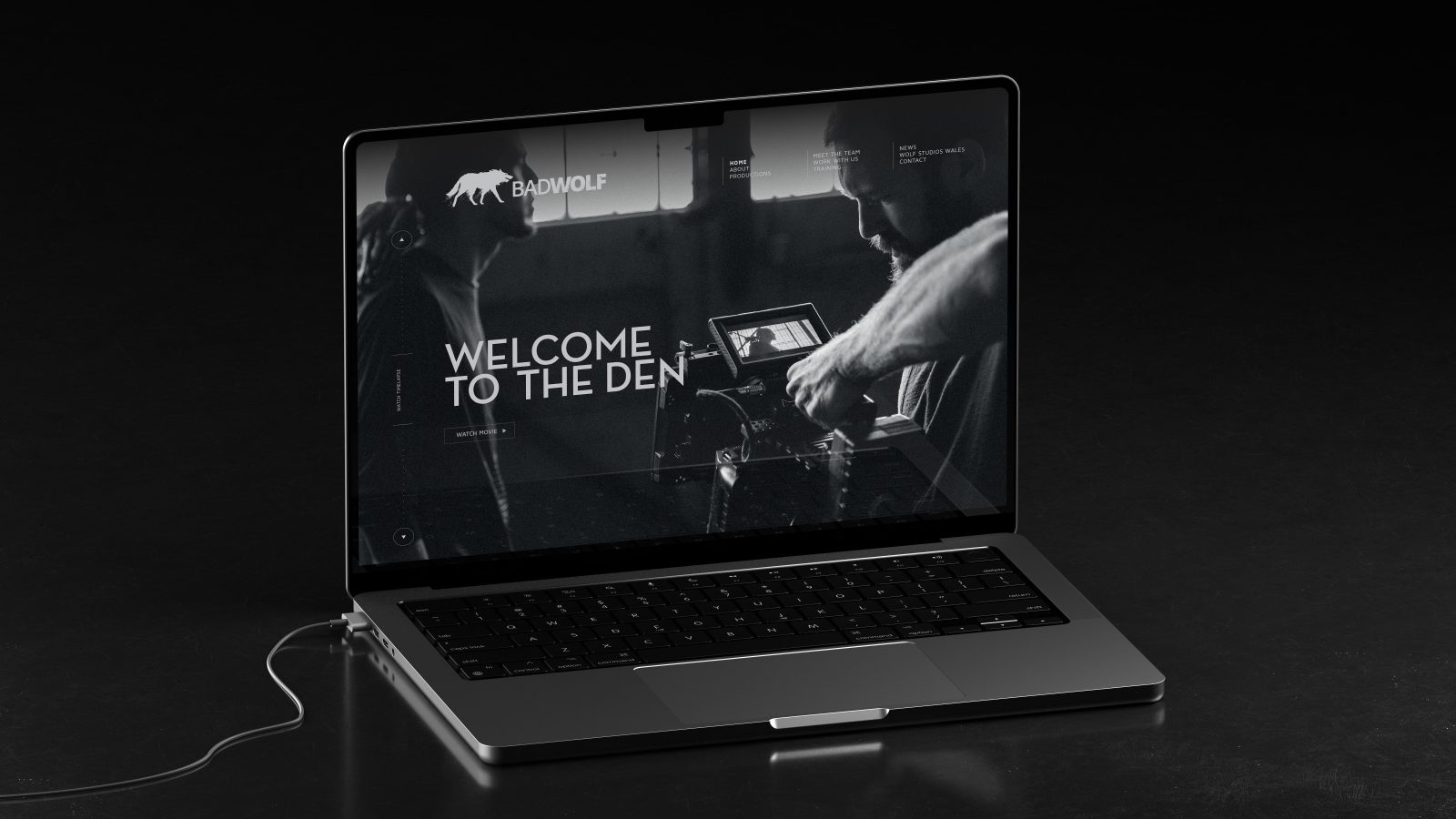 A laptop on a dark surface displaying a welcome screen with the text 