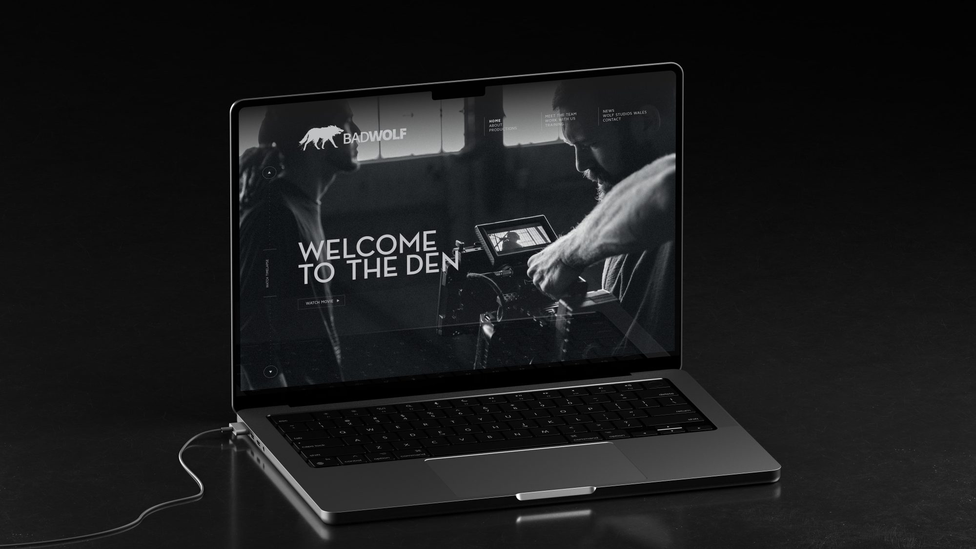 A laptop on a dark surface displaying a welcome screen with the text 