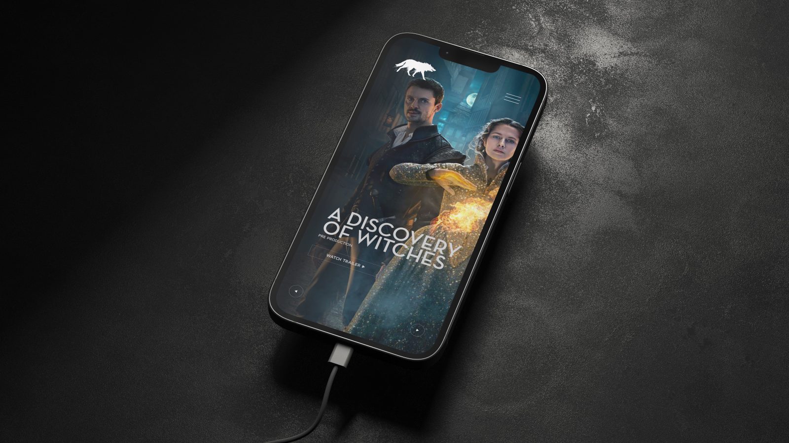 A smartphone lying on a dark textured surface with its screen displaying the poster for 