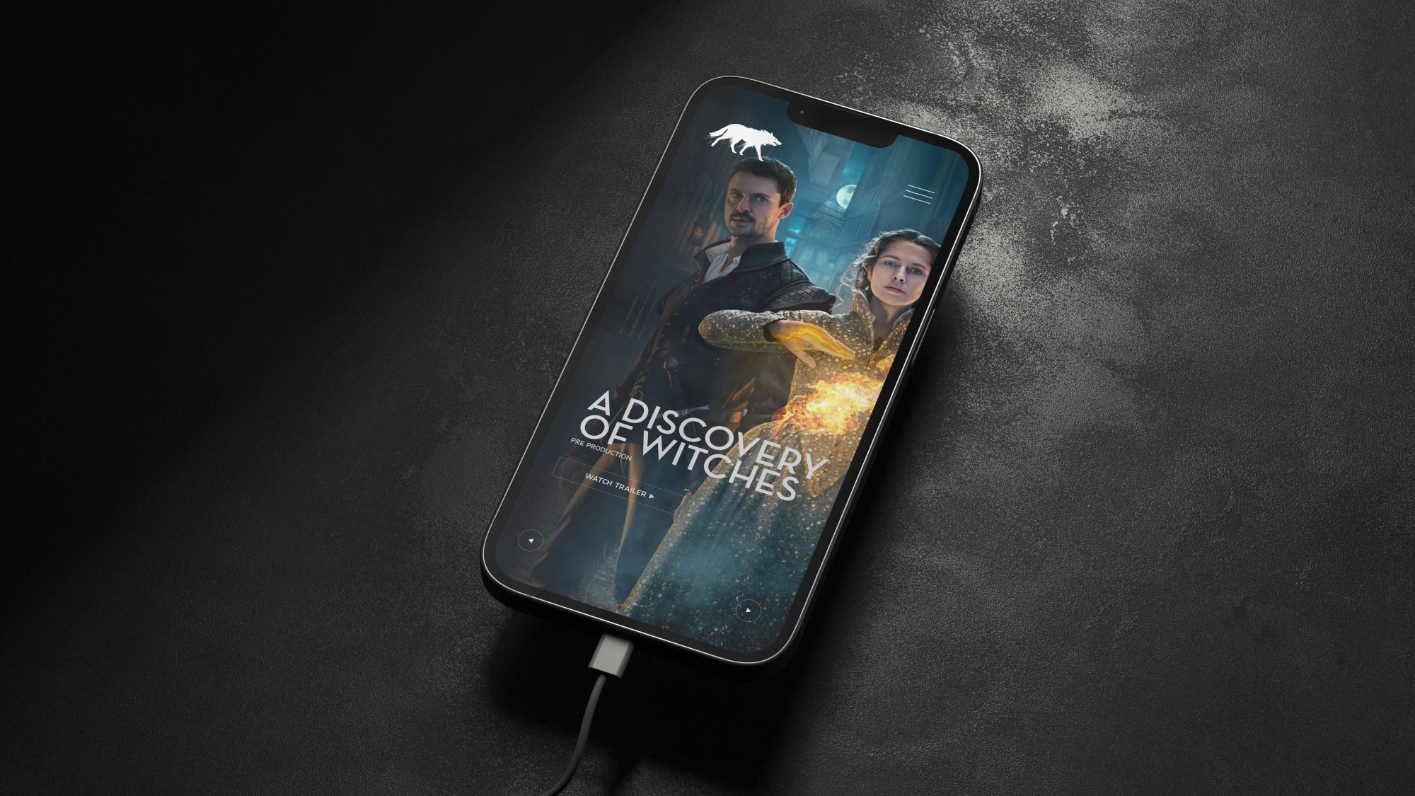 A smartphone lying on a dark textured surface with its screen displaying the poster for 