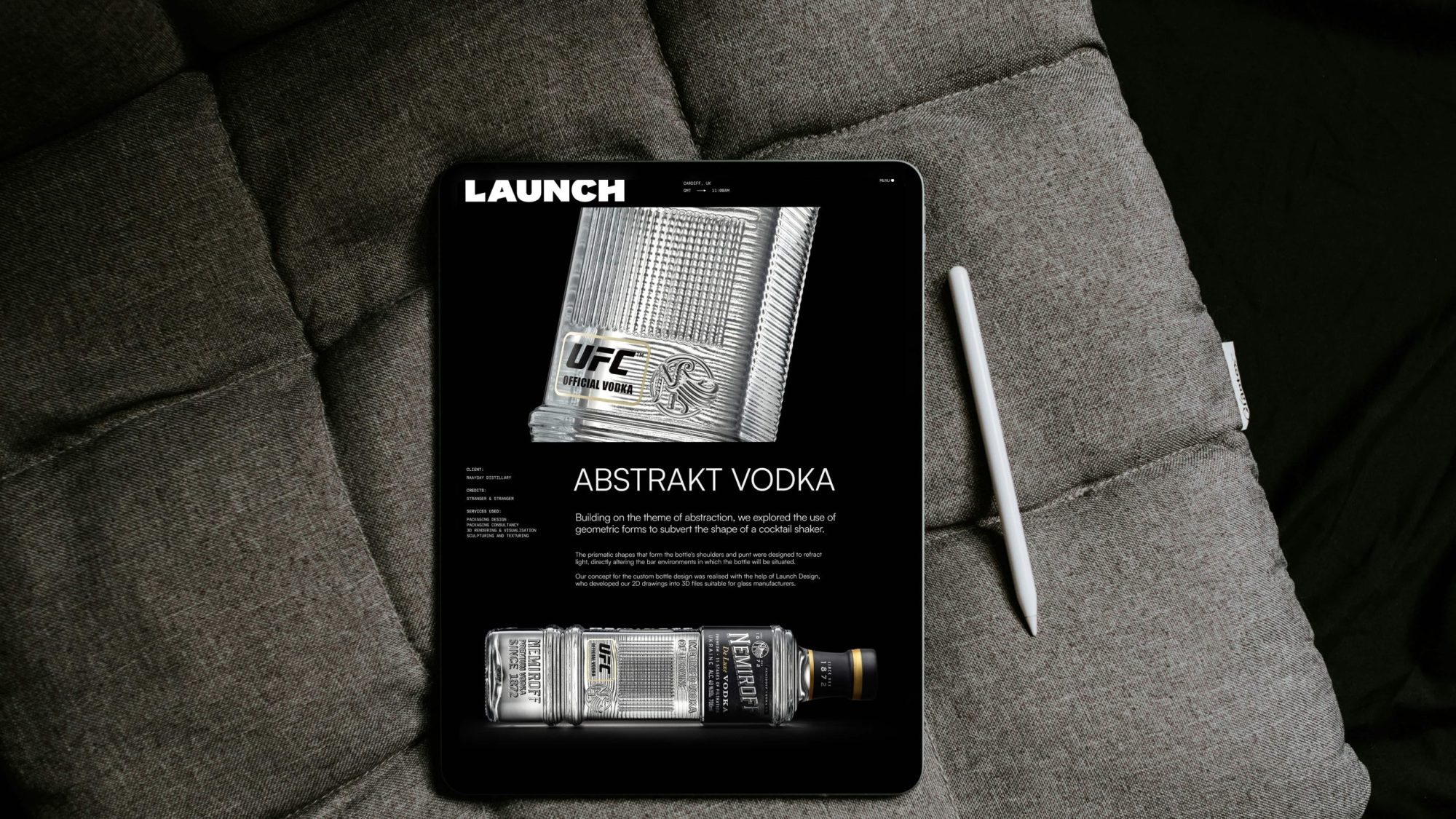 A tablet displaying an Abstrakt Vodka advertisement sits on a gray cushioned surface, with a stylus resting beside it, evoking the intrigue of a cunning bad wolf lurking in the shadows.